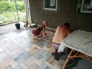 Мы с Лизой кладем плитку на веранде.